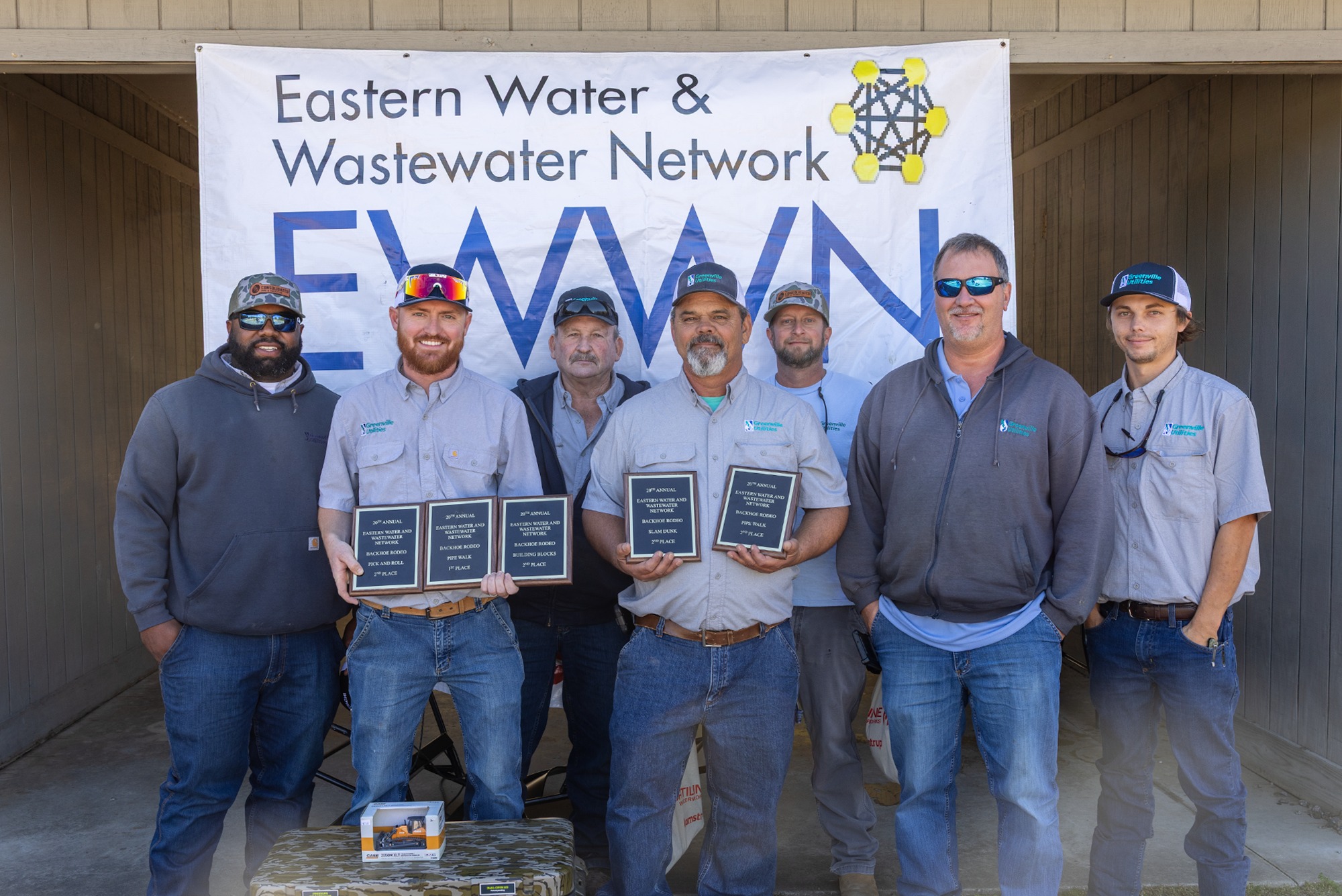 Group of men stand with award